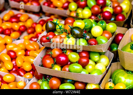 Specialty red, yellow and green cherry tomatoes at a farmer's market, Victoria Park Market, London, UK Stock Photo