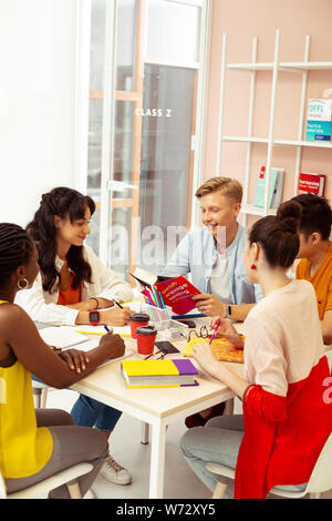 Positive delighted young people discussing their task Stock Photo