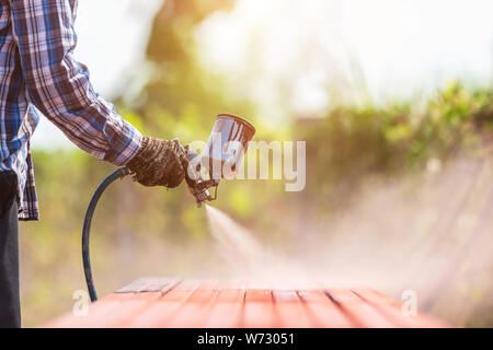 Construction worker spraying paint to steel pipe to prevent the rust on the surface Stock Photo