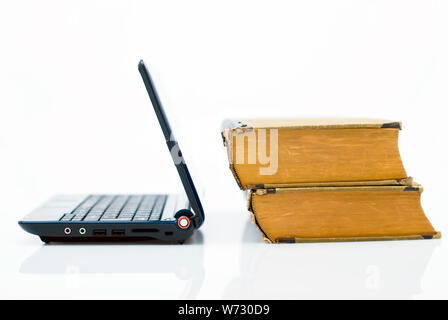 Notebook with opened lid with 2 books on the right, isolated on white. Education in new era of technology Stock Photo