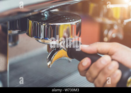 Hand of barista holding coffee tamper and making coffee preparation service in cafe concept Stock Photo