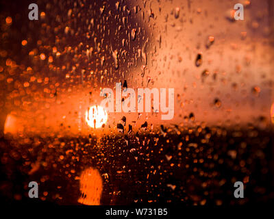 The setting sun through a rain covered window, UK Stock Photo