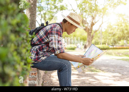 Asian tourist man looking to map in Sukhothai historical park, Northern of Thailand Stock Photo