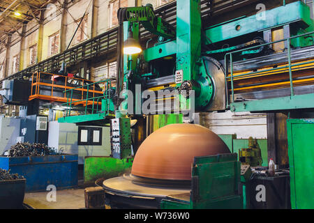 Workers in a foundry grind castings with a grinding machine - Heavy industry workplace. Stock Photo