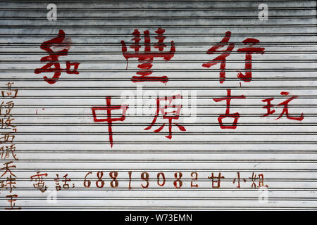 Red Chinese characters on a coiling door in Sheung Wan, Hong Kong Stock Photo