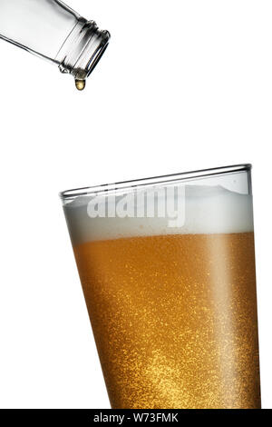 Empty bottle with last drop falling into a freshly poured full glass of beer Stock Photo