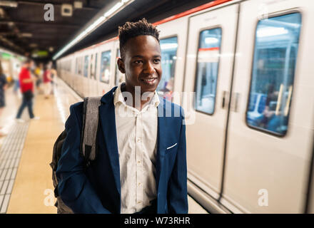 African American businessman wearing blue suit and backpack Stock Photo