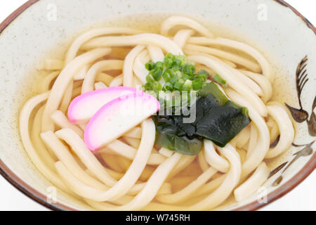Japanese Kake udon noodles in a ceramic bowl on white background Stock Photo
