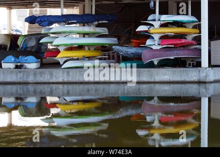 Colourful reflections in the lake from the canoes and kayaks in storage at Dow's Lake Pavilion, Ottawa, Ontario, Canada. Stock Photo