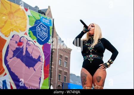 Amsterdam, Netherlands. 04th Aug, 2019. Mutya Buena is seen signing with a banner of the Pride Amsterdam behind her. The former member of the Sugababes, Mutya Buena, gave a performance during the final concert of the Pride Amsterdam at the Dam square, in the center of the city. On Sunday, the official end - party, where there is always a colourful collection of artists enters the stage. Credit: SOPA Images Limited/Alamy Live News Stock Photo