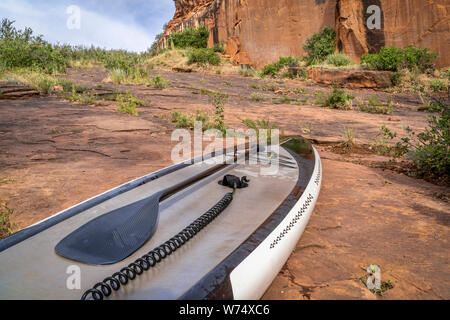 up paddleboard  with a paddle and safety leach on rocky lake shore - old sandstone quarry at Horsetooth Reservoir, Fort Collins, Colorado Stock Photo