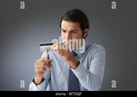 Businessman cutting a credit card with scissors Stock Photo