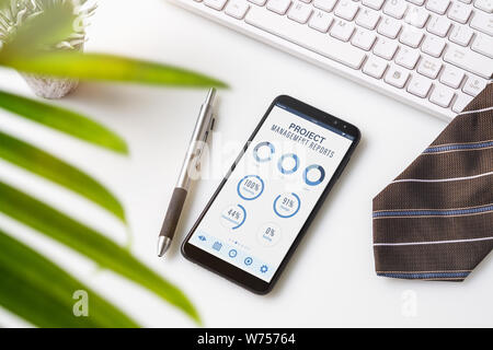 Project management dashboard reports data analytics concept. Close up of smart phone with project management dashboard reports mobile appliaction. Pro Stock Photo