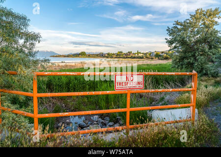 No Trespassing sign on an old metal railing with peeling orange paint Stock Photo