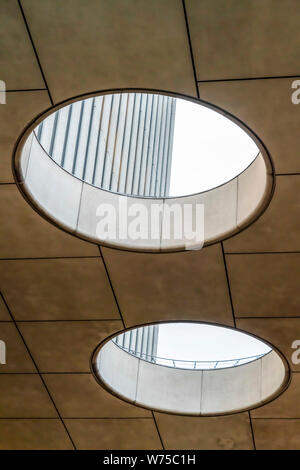 Circular skylights inside a building with view of the concrete exterior wall Stock Photo