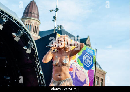 Amsterdam, Netherlands. 04th Aug, 2019. Host Amber Vineyard speaks to the public from the stage. The official end - party where there is always a colourful collection of artists enters the stage took place at the famous Dam square in Amsterdam. This year's performances of Conchita, Mutya Buena, Netta, Paul Morris, Mayré Martinez, Channah Hewitt, etc and hosting by one of the Pride ambassadors, Amber Vineyard. Credit: SOPA Images Limited/Alamy Live News Stock Photo