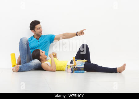 Young couple taking a break while painting their home Stock Photo