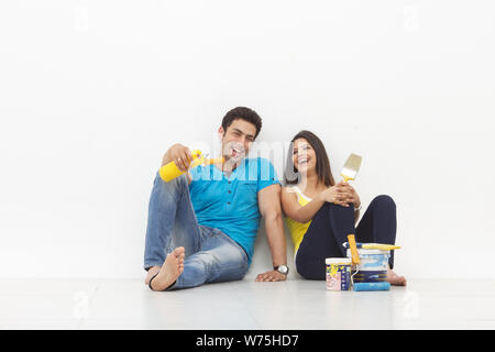 Young couple taking a break while painting their home Stock Photo