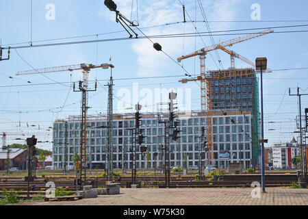 Mannheim, Germany - July 2019: Big construction area surrounded by multiple orange tower cranes next to main station Stock Photo
