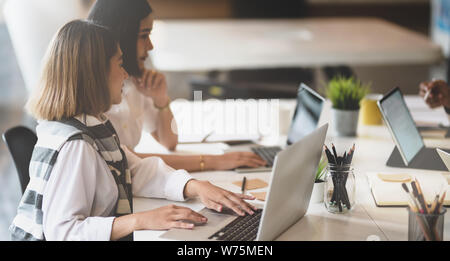 Two young beautiful startup members reviewing previous startup concepts to get new ideas Stock Photo