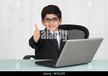 Boy pretending to be a businessman showing thumbs up sign Stock Photo
