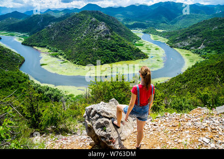 Montenegro, Gorgeous young woman with long hair standing at rock above crnojevica river water bend in green canyon national park skadar lake nature sc Stock Photo