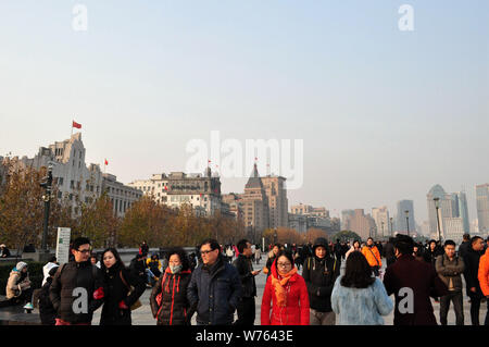 Tourists crowd the promenade on the Bund along the Huangpu River on the Christmas Eve Festival in Shanghai, China, 24 December 2017.   Chinese people Stock Photo
