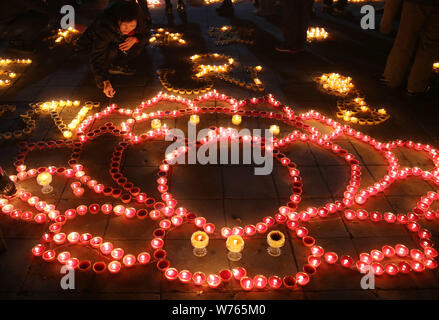 Chinese worshippers light butter lamps to pray for good fortune during a memorial festival of Tsong Khapa's death at the Guangren Lama Temple in Xi'an Stock Photo