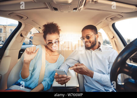 African-american couple using navigator app on phone in car Stock Photo