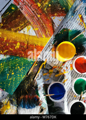 colorful bright colors, brushes and abstract painting on newspaper background. cans of different colors and contemporary art Stock Photo