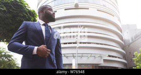 Confident black businessman against modern office center background Stock Photo