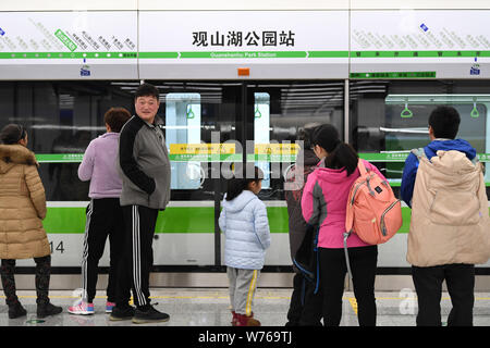 Passengers wait for a subway train at the Guanshanhu Park Station on the Metro Line 1 in Guiyang city, southwest China's Guizhou province, 28 December Stock Photo