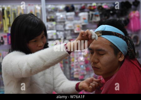 FILE 46 year old Chinese woman helps a customer remove his