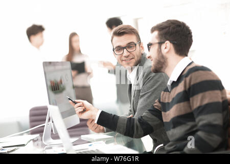 Two businessmen in office analyze rising project statistics on laptop screen Stock Photo