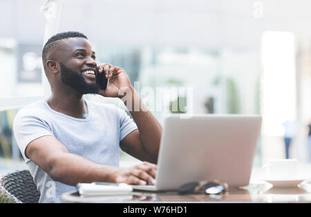 Young handsome african guy working on laptop Stock Photo
