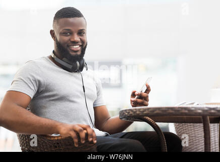 Handsome african man sitting in cafe and waiting for order Stock Photo