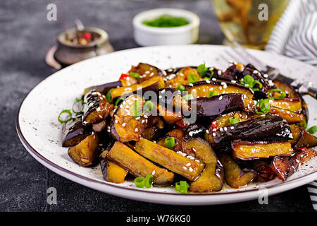 Hot spicy stew eggplant in Korean style with green onion. Aubergine saute. Vegan food. Stock Photo