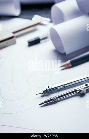 On a wooden table are drawings, compasses, pencil, ruler and sharpener. Stock Photo