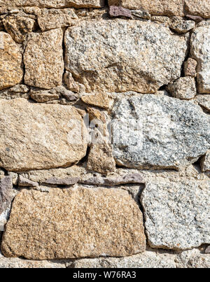 Detail of an old stone wall arranged in an irregular manner. Architecture constructions. Vintage background. Stock Photo