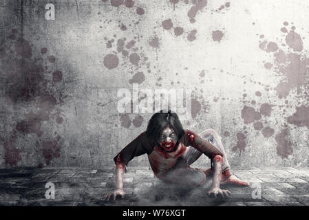 Scary zombies with blood and wound on his body crawling on the urban street. Halloween concept Stock Photo