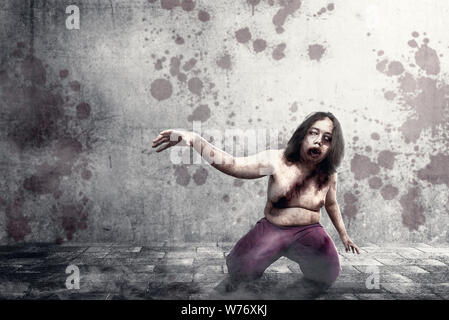 Scary zombies with blood and wound on his body crawling on the urban street. Halloween concept Stock Photo