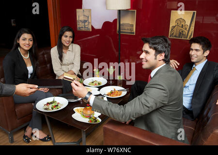 Business executives paying bill by credit card in a restaurant Stock Photo