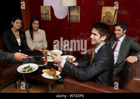 Indian business executives paying bill by credit card in a restaurant Stock Photo