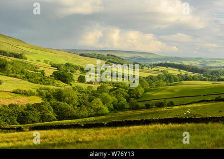 Long-distance picturesque evening view to Wharfedale (rolling clouds & hills, green pasture, sunlit valley) - Beamsley, Yorkshire Dales, England, UK.
