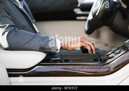 Businessman driving car, holding hand on gearbox Stock Photo