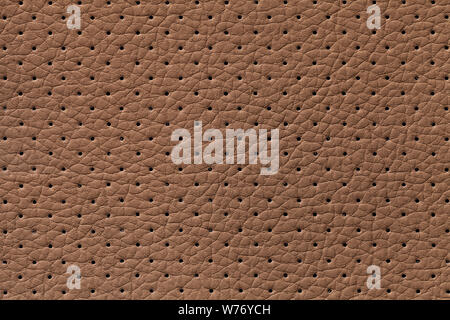 Perforated brown leather texture background, closeup. Bronze backdrop from wrinkle skin, structure of textile. Stock Photo