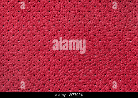 Perforated wine leather texture background, closeup. Dark red backdrop from wrinkle skin, structure of textile. Stock Photo