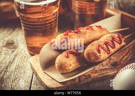 Corn dogs and beer on rustic background Stock Photo