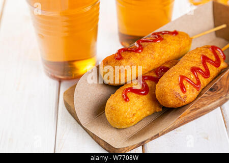 Corn dogs and beer on rustic background Stock Photo