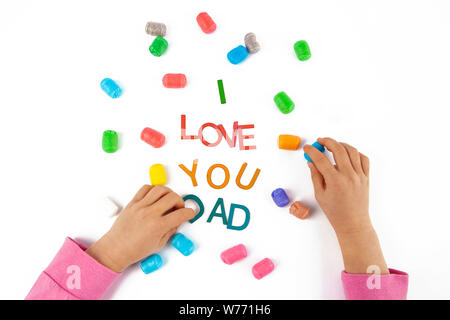 Child hands made the words I love You Dad from colorful letters for fathers day. Top view on white background Stock Photo